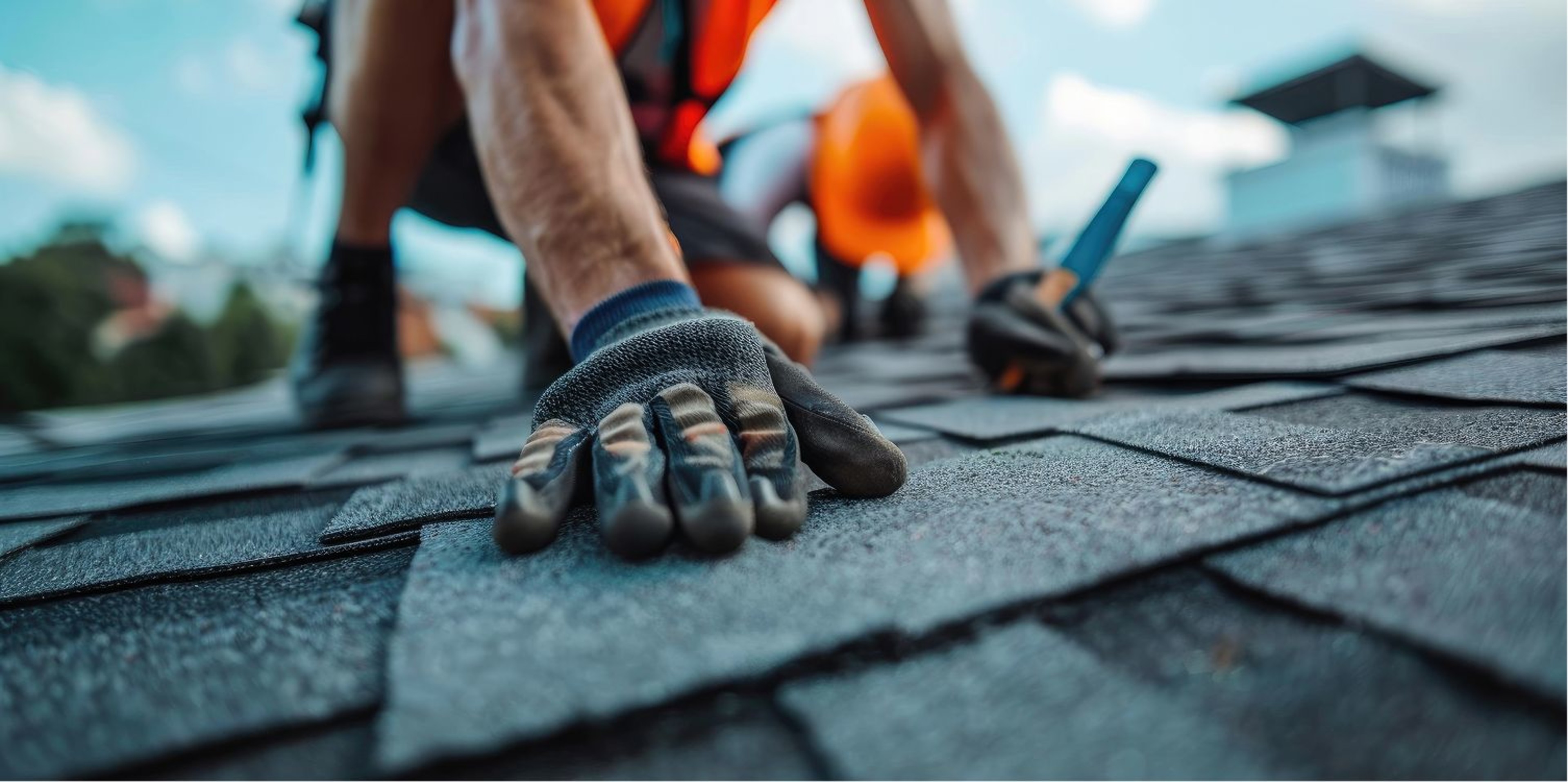 Gloved hand on shingle roof